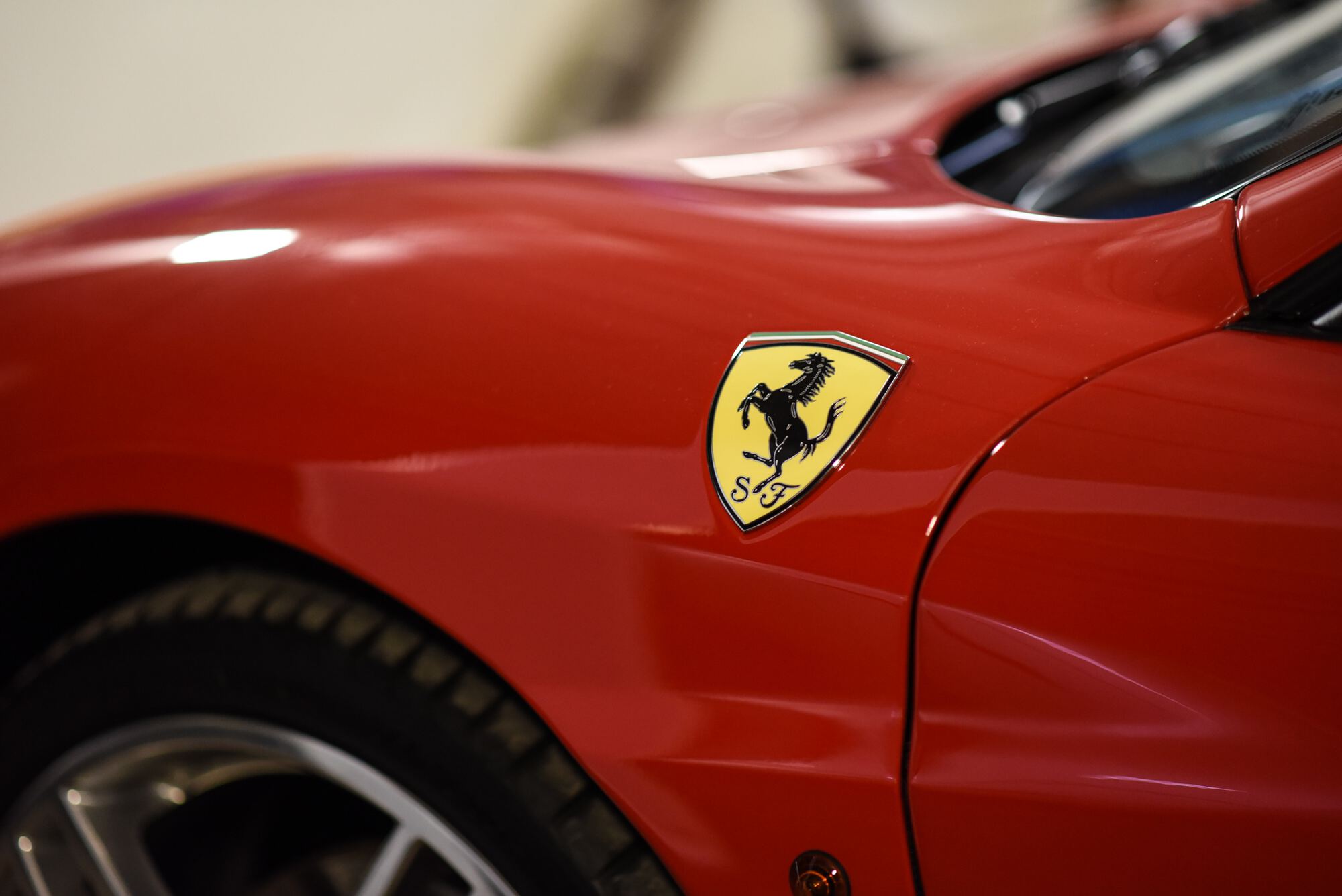 Close view of a hand-polished red front wing and marque badge